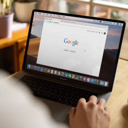 Person using Google Search on a laptop, where AI Overviews take a single position