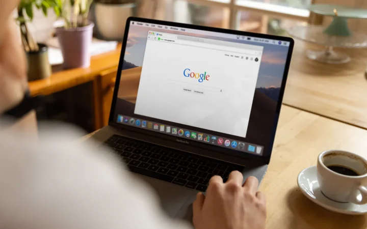 Person using Google Search on a laptop, where AI Overviews take a single position