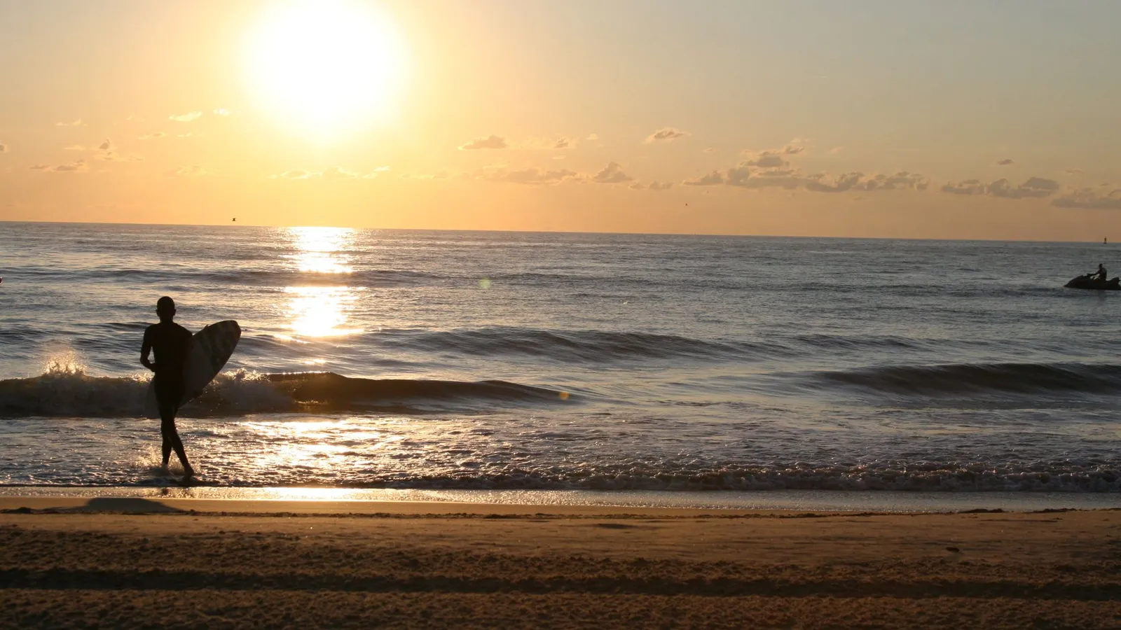 Surfer silhouetted at sunrise on Virginia Beach, the city whose SEO agencies are reviewed in this guide