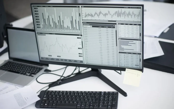Analytics dashboards on a desk monitor and laptop, used to compare Search Console clicks with GA4 sessions