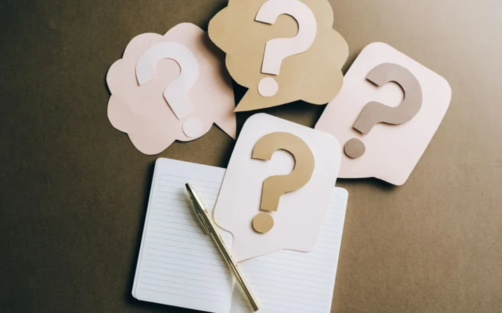 Paper question mark cards on a notebook, representing FAQ schema questions in Google Search