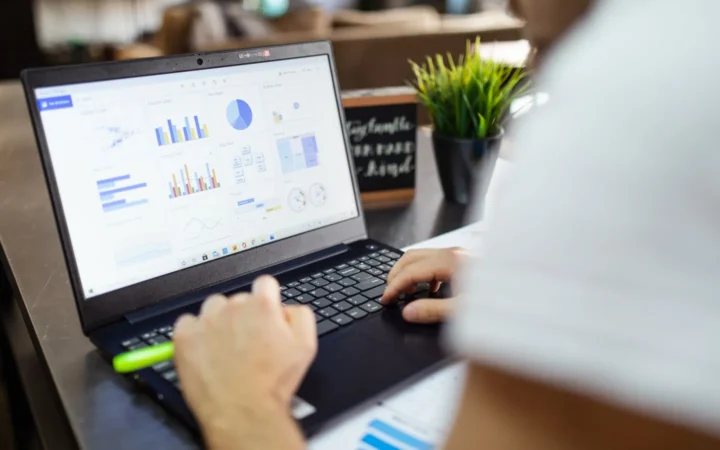 Person working with a data dashboard on a laptop after exporting generative AI performance data