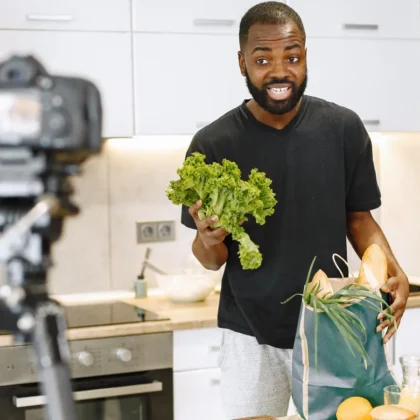 YouTube creator filming a cooking video on a tripod camera, comparing Shorts and long videos in Search Console